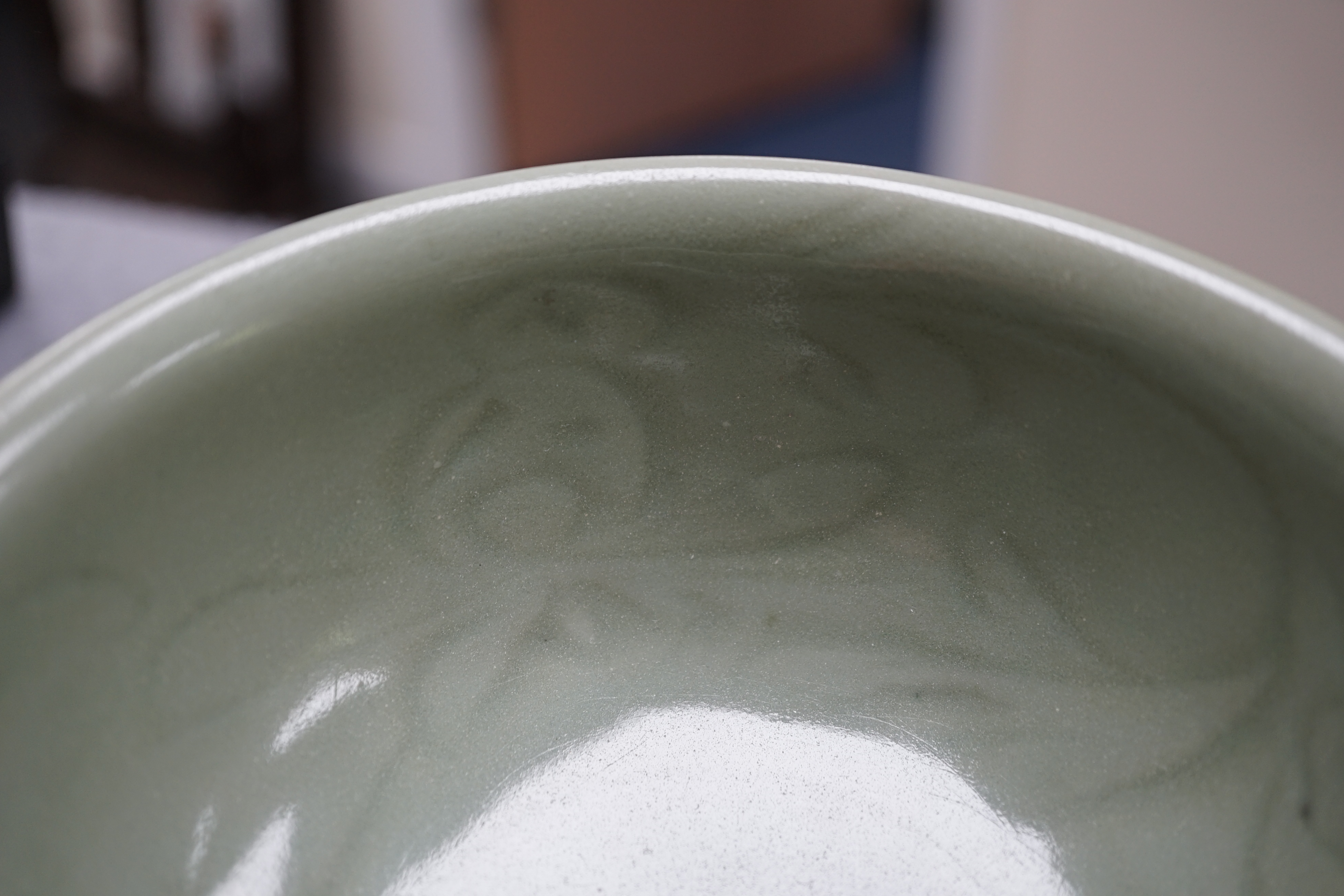 A Chinese Longquan celadon bowl, the interior carved with lotus flowers and the exterior with foliate lappets, 15.2cm diameter., Provenance - Robert Ricketts collection, formerly sold by Robert McPherson, London and S. M